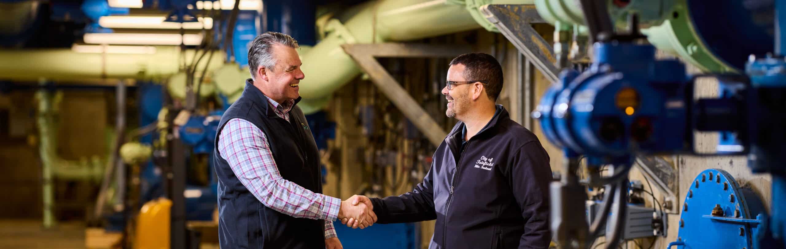 Two men shaking hands in a facility