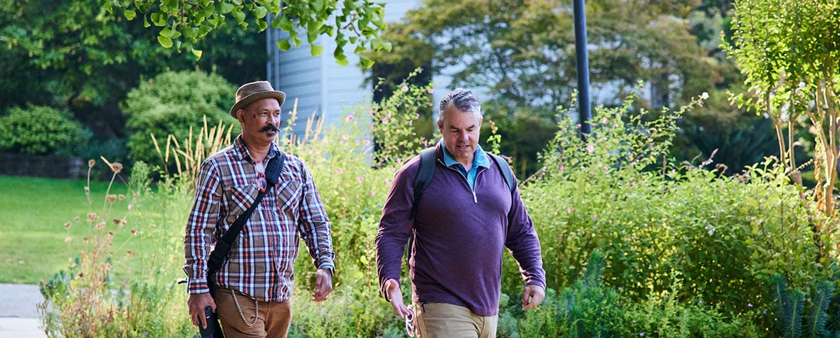 Two men walking in a park.